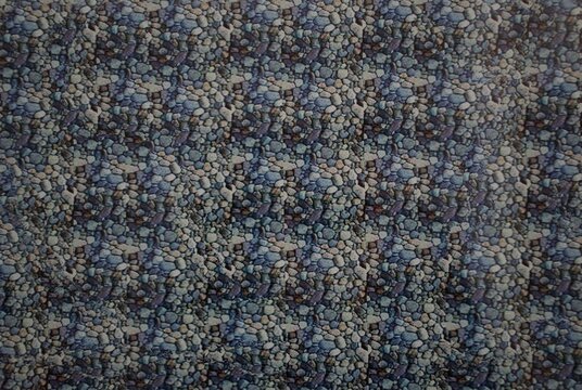 Abstract stereogram image featuring a repeating pebble texture that conceals a hidden 3D illusion when viewed with depth perception. Blue, gray, and brown stones creates a natural, texture.