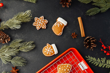 Christmas cookies on dark surface with pine branches cinnamon and pinecones
