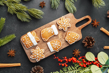 Gingerbread cookies shaped like snowflakes mittens tree present decorated with icing on board winter