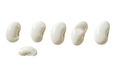 Seven smooth, white lima beans arranged on a black background