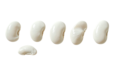 Seven smooth, white lima beans arranged on a black background