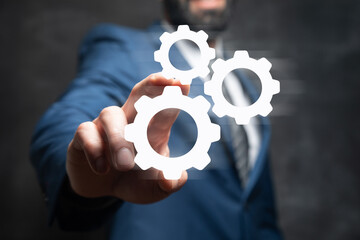 Businessman and blue gear icon on screen. Concept of the mechanism