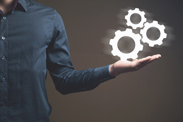 Businessman and blue gear icon on screen. Concept of the mechanism