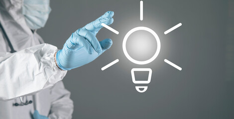 A doctor in white presses a lamp on the screen.