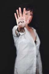 Young woman with hand writing stop