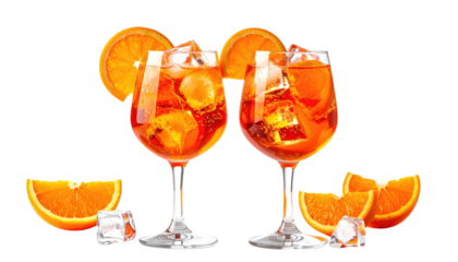 Two spritz cocktails with ice, orange slices on black backdrop
