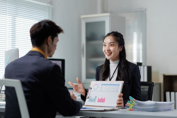 Asian businesswoman presenting business report to male client