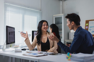 Asian business professionals discussing project strategy in office