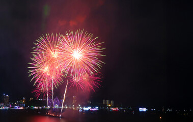Fantastic fireworks detonating in the night sky over the city harbor