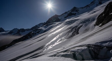 A brilliant sun shines above a snowy, mountainous terrain with glaciers and deep shadows