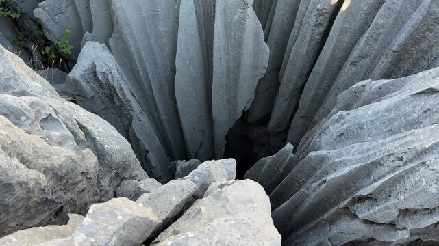 unusual rock structure with deep pits and surrounding karst formations