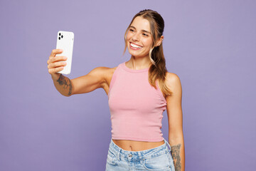 Young happy woman wear pink tank top casual clothes doing selfie shot on mobile cell phone post...