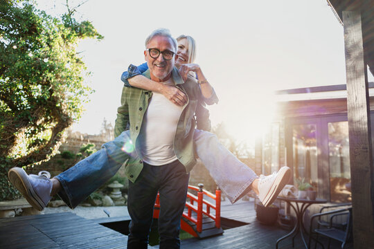 Playful senior couple enjoying time together in their backyard