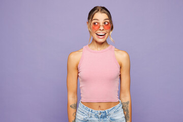 Young shocked surprised smiling happy woman wear pink tank top casual clothes sunglasses look aside...