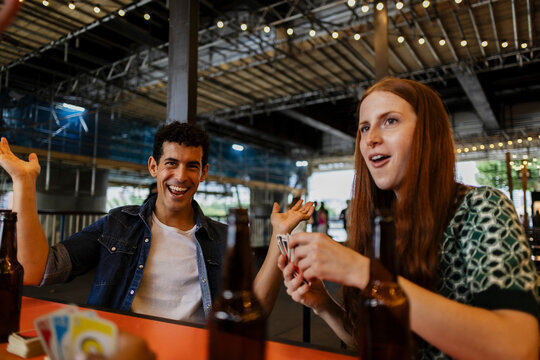 Friends enjoying a card game and beer at a brewery having fun
