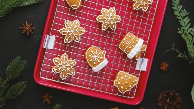 Festive homemade gingerbread cookies shaped like snowflakes mittens and trees cooling on a rack.