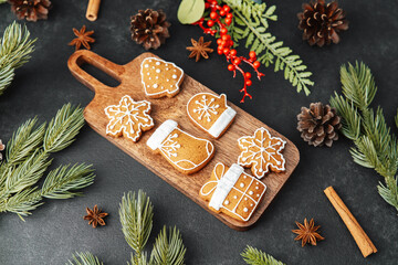 Decorated festive holiday cookies arranged on a wooden board with pine needles and cones.