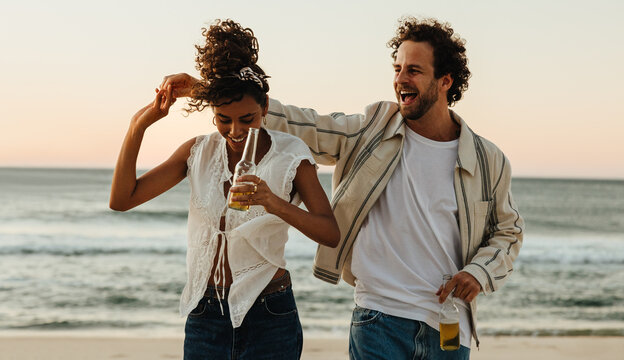 Joyful couple enjoying a relaxed day on the beach at sunset
