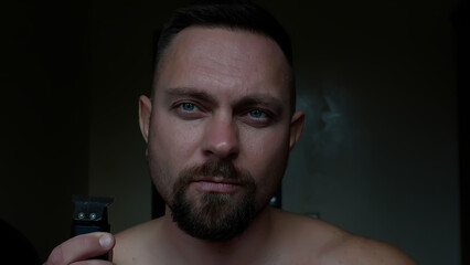 Men's face shaving. Close-up of a man's face, beard shaving, long 4K video. A man shaves his beard with a trimmer.