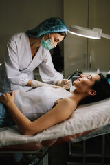 Dermatologist performs precise radio wave mole removal using radiofrequency surgery. Close-up of radio wave dermatologic mole excision. Radiofrequency mole removal under clinical conditions.