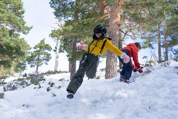 Children jumping and playing in snowy forest during winter day