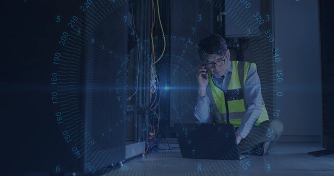 Crouching technician in neon safety vest holding smartphone over laptop in server room, amid cables - Powered by Adobe