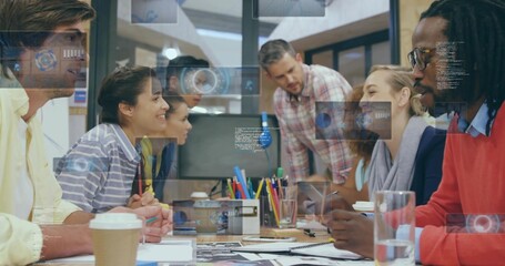Collaborating team reviewing printed sketches on laptops in conference room, with data overlays