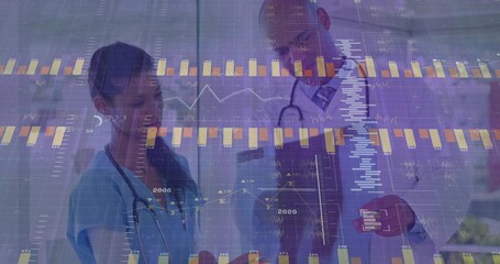 Examining nurse and doctor analyzing data in corridor, with stethoscopes, clipboard and charts