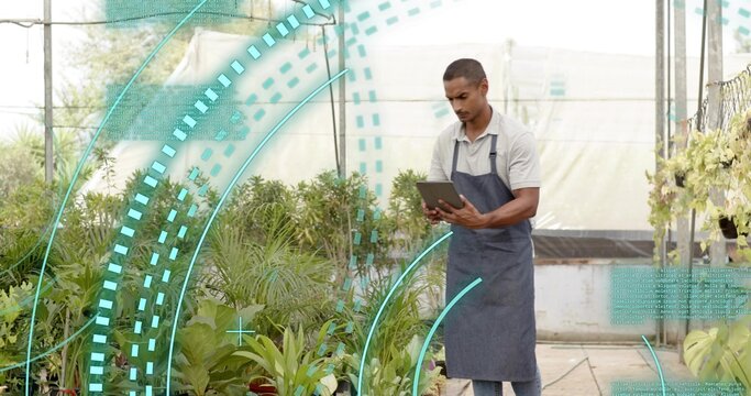 Studying horticulturist holding tablet inside greenhouse with potted plants and beams, copy space - Powered by Adobe