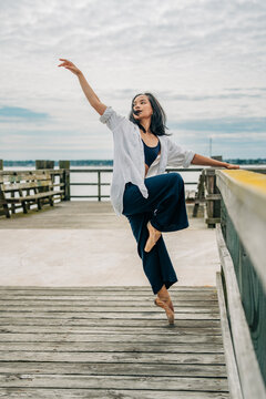Female dancer on pointe posing on wooden dock