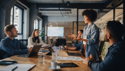 Diverse group of professionals meeting around a table with laptops, discussing ideas and strategies, concept for business development, corporate training and innovation