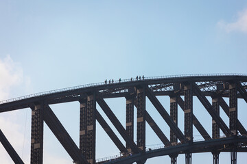 High-quality photos of the Sydney Harbour Bridge with people climbing along its arch during the Harbour Bridge experience, captured on a bright day with clear skies — perfect for wall art.
