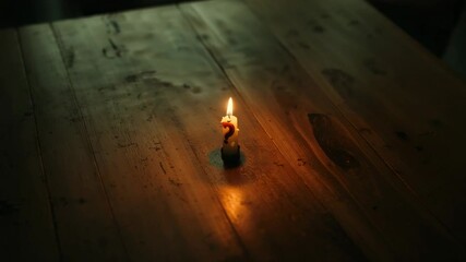 Flickering number 2 wax candle flame reacting to air currents on wooden table, with melted wax - Powered by Adobe