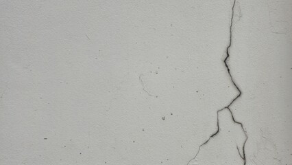 The white painted walls of the house have cracks, peeling paint and stains. The texture of the...