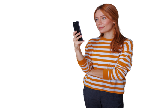 Redhead woman holding smartphone, smiling, using modern network technology for communication and digital content, transparent background