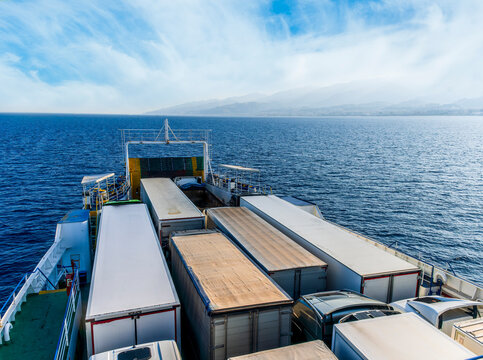 naval transport cargo ferry ship transporting wagon trucks to a destination port to supply trade goods to commercial sea port throuth sea and ocean