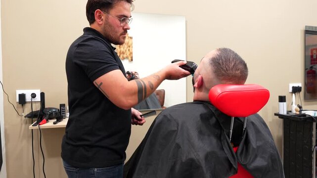 Close-up of focused barber carefully shaving client&rsquo;s moustache