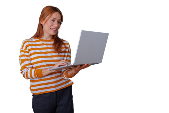 Young woman smiling, holding and typing on a laptop computer, engaged in work or online activities with a transparent background