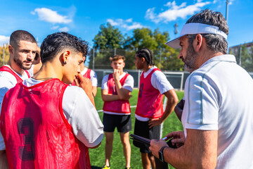 Soccer coach explaining strategy to junior team players