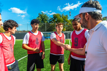 Coach shaking hands with player on soccer field