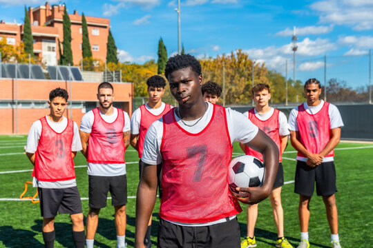 Diverse soccer team standing on a football pitch