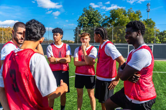 Soccer team huddle discussing strategy on sports field