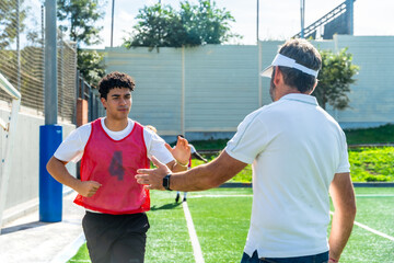 Soccer coach mentoring young player during training