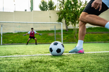 Obraz premium Football player taking penalty kick against goalkeeper