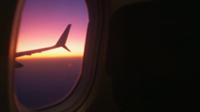 Showing camera during bank revealing wing through cabin window, with vibrant sky gradient