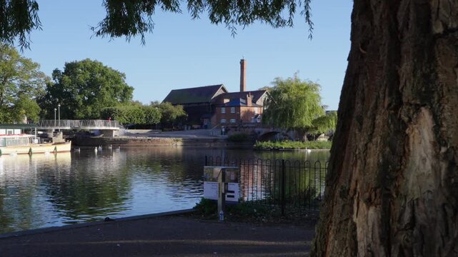 Camera slides to reveal River Avon and Tramway House in Stratford-upon-Avon. Cox Island is also seen