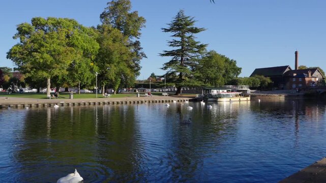 Slow pan from Tramway Bridge to Royal Shakespeare Theatre across River Avon in in Stratford-upon-Avon on a sunny autumn morning 