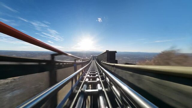 Pulling alpine coaster car by gravity into steep drop on ridge, with blurred rails, fence, wall