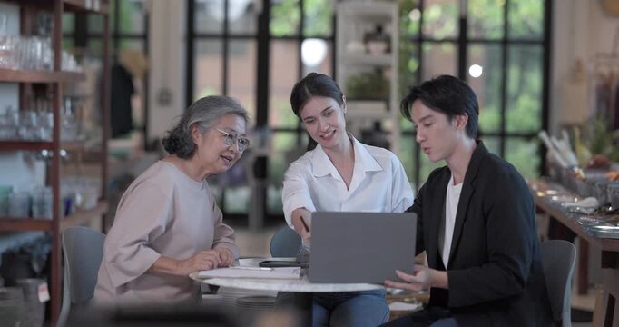 An Asian male investor and team meet with senior female owner at family business ceramic retail shop, negotiating and signing a partnership contract to expand retail and wholesale opportunities.
