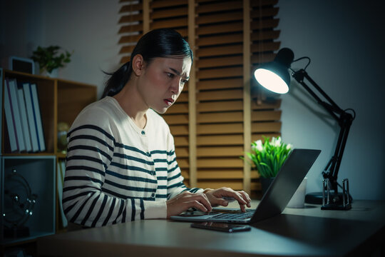 stressed woman working with laptop at night
